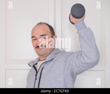 Homme asiatique en activité physique à la maison avec des équipements sportifs. Banque D'Images