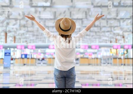 Concept voyage et été, jeune femme en chapeau debout à l'aéroport Banque D'Images