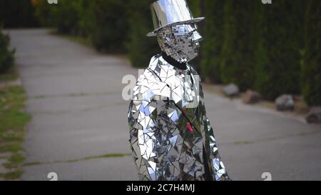 Montrez l'homme en costume miroir et chapeau debout sans mouvement comme statue. Photo de prise de vue latérale. Restaurant Dva Bobra. Ukraine- Kiev- 09.07.2018 Banque D'Images