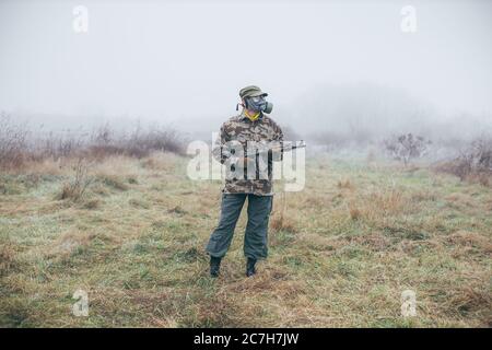 soldat avec arme automatique portant un masque à gaz comme protection contre les armes chimiques Banque D'Images