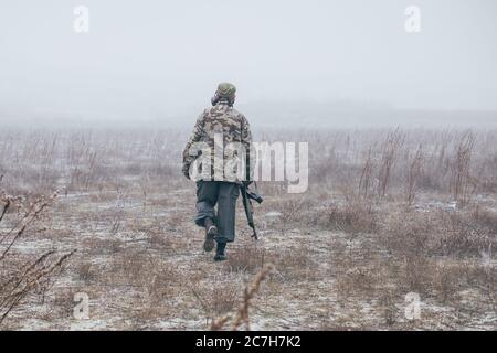 déserteur quittant le champ de guerre avec l'arme en main Banque D'Images
