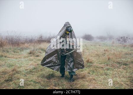 soldat avec mitrailleuse portant un costume de protection contre les armes chimiques Banque D'Images