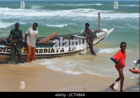 Pêcheurs artisanaux poussant les pirogues hors de l'eau à Lompoul, Sénégal Banque D'Images