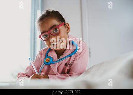 Fille multiraciale habillée comme un médecin regardant appareil photo Banque D'Images