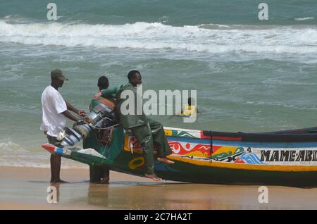 Pêcheurs artisanaux poussant les pirogues hors de l'eau à Lompoul, Sénégal Banque D'Images