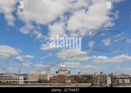 Londres, Royaume-Uni. 17 juillet 2020. Un artiste de fabrication de bulles de savon divertit les enfants et les adultes devant une magnifique toile de fond de la cathédrale Saint-Paul. Le soleil est agréable et les températures chaudes sont sur le bon pour continuer le week-end. Crédit : Imagetraceur/Alamy Live News Banque D'Images