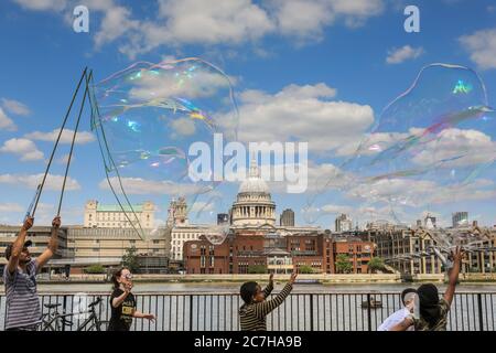 Londres, Royaume-Uni. 17 juillet 2020. Un artiste de fabrication de bulles de savon divertit les enfants et les adultes devant une magnifique toile de fond de la cathédrale Saint-Paul. Le soleil est agréable et les températures chaudes sont sur le bon pour continuer le week-end. Crédit : Imagetraceur/Alamy Live News Banque D'Images