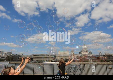 Londres, Royaume-Uni. 17 juillet 2020. Un artiste de fabrication de bulles de savon divertit les enfants et les adultes devant une magnifique toile de fond de la cathédrale Saint-Paul. Le soleil est agréable et les températures chaudes sont sur le bon pour continuer le week-end. Crédit : Imagetraceur/Alamy Live News Banque D'Images