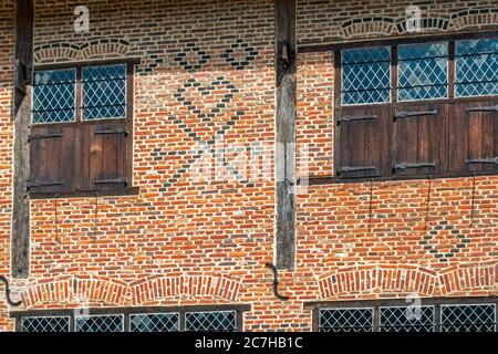 Symboles du maçon flamand en briques sur la façade de la maison en briques du XVIe siècle montrant des checks, des coeurs et des croix de Saint-André, Flandre, Belgique Banque D'Images