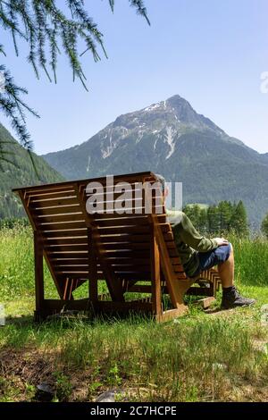 Europe, Autriche, Tyrol, Alpes de l'Ötztal, Ötztal, randonneurs sur un banc avec vue sur le Gamskogel Banque D'Images