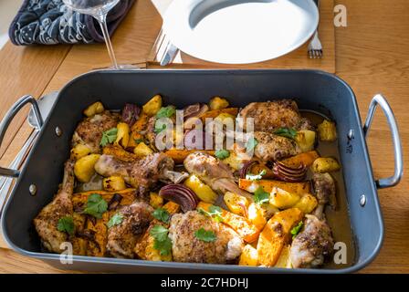 Plat à escalopes et cuisses de poulet jerk cuisez dans un plat à rôtir avec des légumes : patates douces, oignons rouges et morceaux d'ananas Banque D'Images