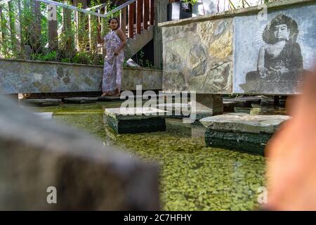 Amérique, Caraïbes, grandes Antilles, République dominicaine, Cabarete, femme bénéficie de la paix dans un étang à poissons dans la zone de yoga du Natura Cabana Boutique Hotel & Spa Banque D'Images