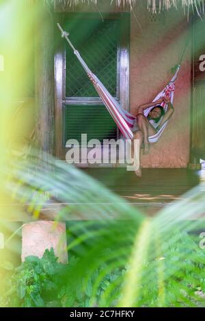 Amérique, Caraïbes, grandes Antilles, République dominicaine, Cabarete, femme située dans un hamac sur la terrasse de son bungalow dans le Natura Cabana Boutique Hotel & Spa Banque D'Images