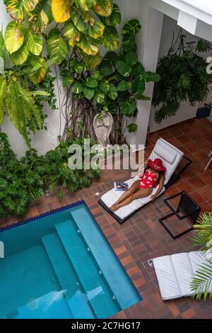 Amérique, Caraïbes, Grande Antilles, République Dominicaine, Saint Domingue, Zona Colonial, Hôtel Colonial 154 H Boutique, femme avec chapeau de soleil sur un transat au bord de la piscine Banque D'Images