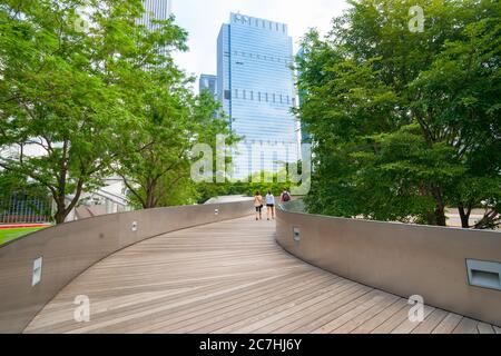 Chicago USA - 28 2015 août ; trois personnes marchant le long du ruban de patinage menant entre la verdure du parc à travers le Millennium Park de Chicago, Illinois, Banque D'Images