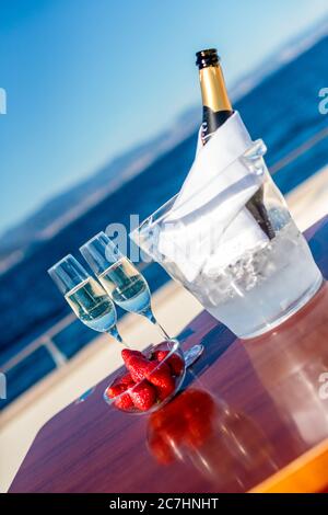 Coupe verticale de verres à champagne remplis près des fraises un bol Banque D'Images
