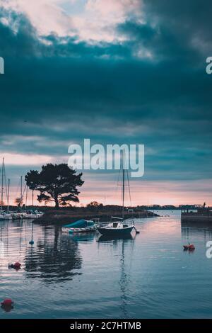 Un yacht ou un bateau à voile dans un port au coucher du soleil à Emsworth, Hampshire, Royaume-Uni Banque D'Images