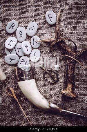 Vue plate sur les pierres d'rune avec divers objets de style de l'ère viking. Concept de style de vie ancestral de divination et de vikings. Banque D'Images