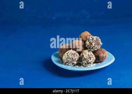 Une partie de boules d'énergie à la maison sur un fond bleu. Dessert délicieux et sain. Style de vie. Gros plan. Copier l'espace Banque D'Images