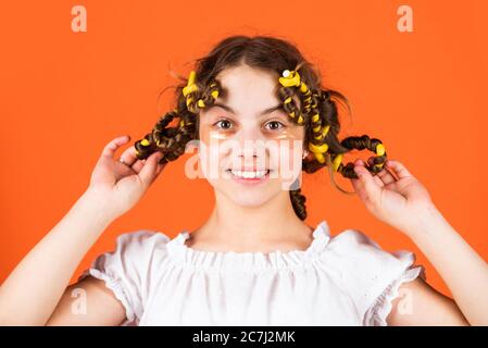 regardez ça. posez avec des cheveux en curlers. bonne fille dans cheveux en curlers jouant salon de coiffure. Conseils faciles pour la coiffure des enfants. Outils de coiffure et accessoires de cheveux. Enfant avec des patches sur le visage. Banque D'Images