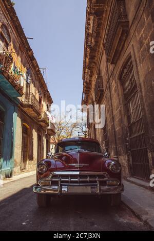 Gros plan d'une voiture rouge classique (vintage) brillante garée dans les rues de la Havane, Cuba Banque D'Images