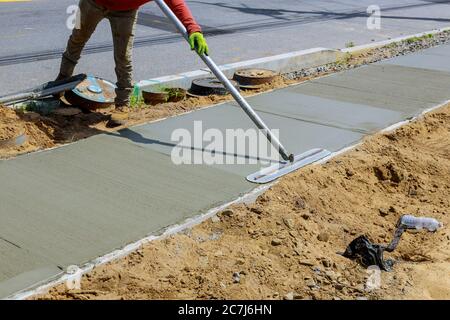 Poser un nouveau trottoir dans du béton humide sur des trottoirs fraîchement coulées Banque D'Images