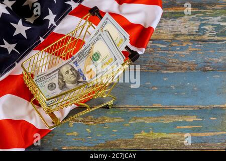 Concept financier de panier avec billets en dollars américains en drapeau américain sur fond de bois Banque D'Images