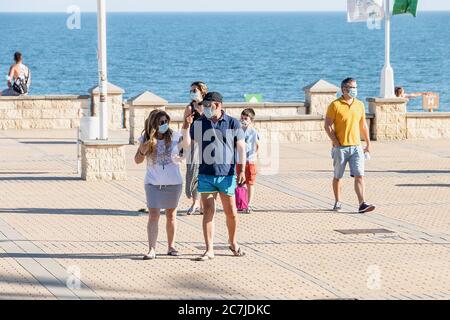 Huelva, Espagne - 3 juin 2020: Personnes marchant par la promenade d'Islantilla portant un masque protecteur dû à Covid-19. Banque D'Images