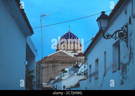 L'église en dôme bleu de la vieille ville vue à travers l'ancienne allée après le coucher du soleil avec lumière bleue à Altea, Costa Blanca, Espagne Banque D'Images