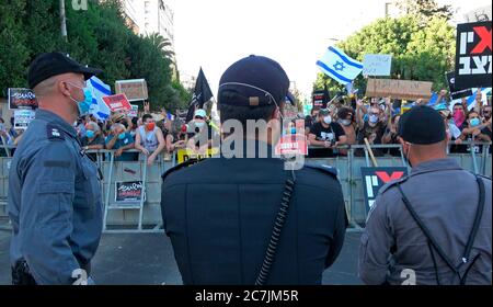 La police veille à ce que les partisans du mouvement de protestation du « drapeau noir » scandent des slogans anti-Netanyahou lors d'une manifestation exigeant la démission du Premier ministre Benjamin Netanyahou suite à des accusations de corruption portées devant sa résidence officielle à Jérusalem en Israël Banque D'Images