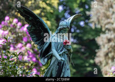 Statue d'ange, rose rouge, fleur de rhododendron, cimetière d'Ohlsdorf, Hambourg, Banque D'Images