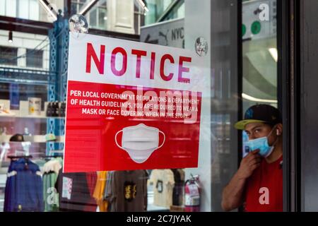 Une enseigne à l'intérieur du magasin PUMA rappelle à ses clients que le port d'un masque est obligatoire, tandis qu'un homme portant un masque de marche quitte le magasin le 17 juillet 2020, à New York. (Photo de Gabriele Holtermann/Sipa USA) crédit: SIPA USA/Alay Live News Banque D'Images
