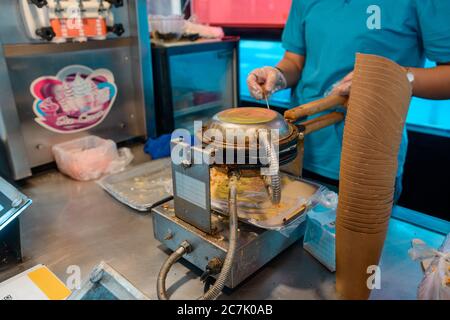 Un vendeur de rue prépare une gaufre d'œufs pour les sundae Banque D'Images