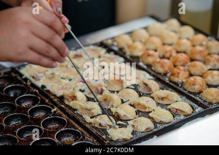 Fabrication de balles Takoyaki. Cuisine de rue asiatique Banque D'Images