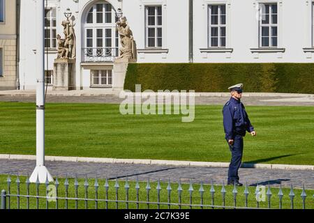 Berlin, Allemagne, mai 6. 2020: Le policier allemand en uniforme bleu avec chapeau blanc à pic marche dans le jardin en face du palais du Président fédéral pa Banque D'Images
