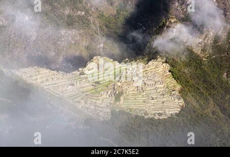 La citadelle Machu Picchu à travers les nuages le matin, vue depuis la porte du Soleil (Inti Punku) entrée de la piste Inca, Urubamba, Pérou Banque D'Images