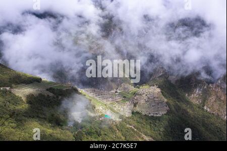 La citadelle Machu Picchu à travers les nuages le matin, vue depuis la porte du Soleil (Inti Punku) entrée de la piste Inca, Urubamba, Pérou Banque D'Images