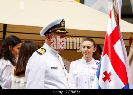 TBILISSI, GÉORGIE - 26 MAI 2018 : portrait maritime géorgien lors de la cérémonie de l'indépendance, une jeune femme marine le fond et le drapeau géorgien. Banque D'Images