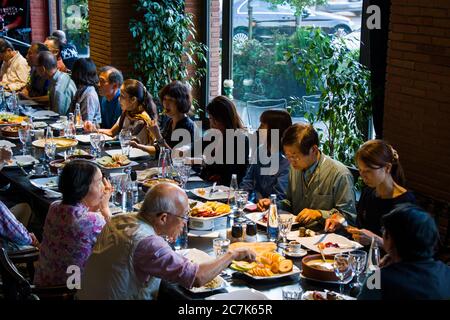 TBILISSI, GÉORGIE - 14 JUILLET 2019 : les touristes asiatiques qui mangent, s'assoir et parlent dans la restauration de Tbilissi. Plats traditionnels et cuisine nationale sur la ta Banque D'Images