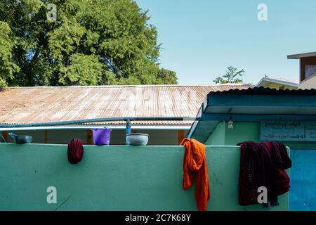 Amarapura, Mandalay, Myanmar - des robes et des paniers colorés sur un mur dans le monastère de Mahagandhayon, le plus important collège monastique du Myanmar. Banque D'Images