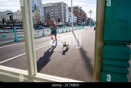 Brighton UK 18 juillet 2020 - UN coureur et son chien sur le front de mer de Brighton ce matin, lors d'une belle journée ensoleillée sur la côte sud avec des températures qui devraient atteindre les 20 dans certaines parties de la Grande-Bretagne : Credit Simon Dack / Alay Live News Banque D'Images