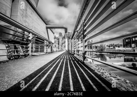 Prise de vue en niveaux de gris d'un pont sous un ciel nuageux Banque D'Images