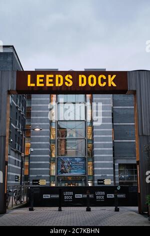 LEEDS, ROYAUME-UNI - 11 janvier 2020 : une photo verticale d'un panneau de Leeds Dock s'éveille dans une nuit de crépuscule avec le Royal Armouries Museum derrière lui Banque D'Images