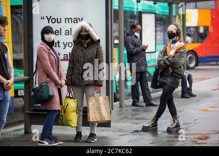 Les passagers de la gare routière Manchester Piccadilly Gardens portent un masque et attendent leur bus Banque D'Images
