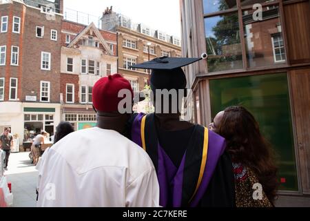 Des étudiants internationaux (africains, chinois, asiatiques, arabes, britanniques) prennent des selfies et célèbrent leur journée de congrégation avec leurs parents et amis dans un Banque D'Images