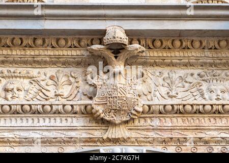 La crête sculptée de l'aigle à deux têtes de Ferdinand d'Aragon et Isabella de Castille décorent l'entablature de la Chapelle Royale de Grenade Banque D'Images