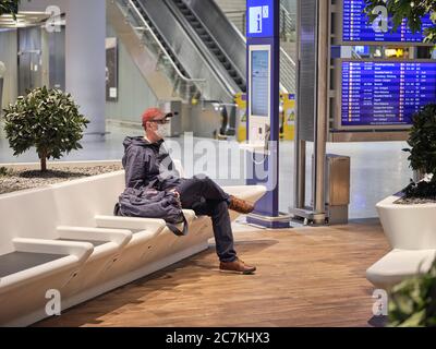 Un voyageur avec un masque facial dans la zone d'attente du terminal 1 de l'aéroport de Francfort pendant le confinement général en Allemagne en raison de la pandémie de couronne. Banque D'Images