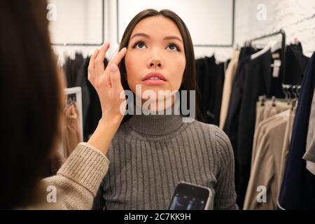 Portrait de la belle fille asiatique élégante sur la mise en place dans magasin de mode Banque D'Images