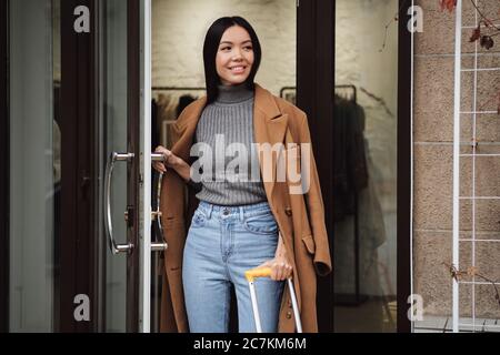 Belle décontractée asiatique fille heureux regarder loin de quitter magasin de mode à l'extérieur Banque D'Images