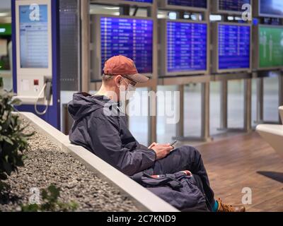 Un voyageur avec un masque facial dans la zone d'attente du terminal 1 de l'aéroport de Francfort pendant le confinement général en Allemagne en raison de la pandémie de couronne. Banque D'Images